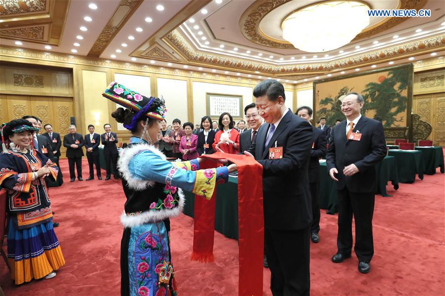 Chinese President Xi Jinping receives Qianghong, a ceremonial silk scarf regarded as a token of respect, from a deputy of Qiang ethnic group when joining a panel discussion with deputies to the 12th National People's Congress (NPC) from Sichuan Province at the annual session of the NPC in Beijing, capital of China, March 8, 2017. Photo: Xinhua