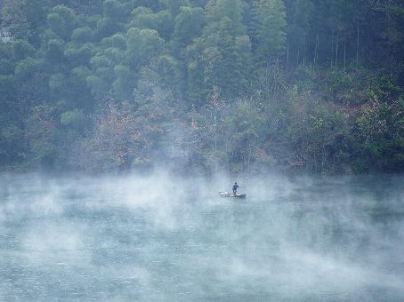 Fishermen fish on smoky lake in China's Zhushan